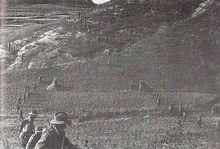 Two lines of evenly spaced soldiers wearing slouch hats advancing across a ridgeline