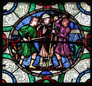Stained glass image of three men. The central man is wearing a mitre and carrying a crozier. The man on the left is wielding a sword that is aimed right at the stomach of the central figure. The third man is throwing up his hands.