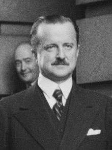 Head and shoulders of well-dressed middle-aged man with small moustache