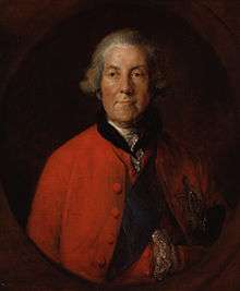 elderly man in a grey wig and red coat