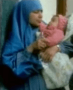 Maha, with her younger daughter in her arms.