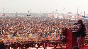 Modi addressing a large crowd from a podium
