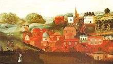 a number of buildings, mainly red, in front of a church on a hill and a row of small trees
