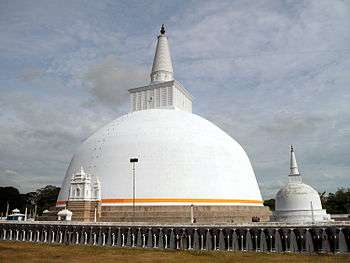 A large white stupa with an orange border near the bottom.