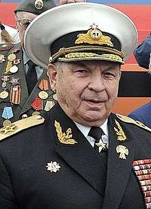 Older, stocky man wearing the white cap and naval uniform of the Russian Navy with numerous decorations and medals.