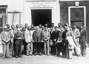 A group of men gathered outside a large building